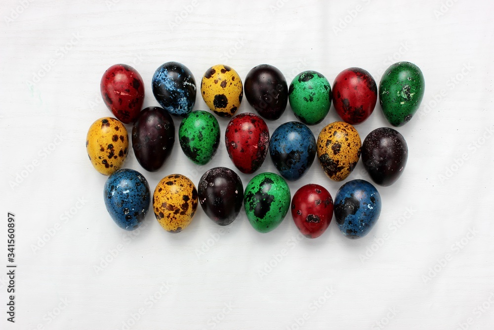 Multi-colored eggs close-up, top view. Set of easter eggs isolated on white. Easter background. Blue, red, green, yellow, purple quail eggs.