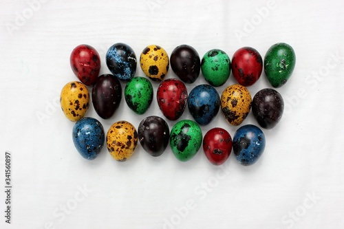 Obraz na płótnie Multi-colored eggs close-up, top view. Set of easter eggs isolated on white. Easter background. Blue, red, green, yellow, purple quail eggs. w salonie