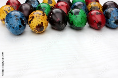 Obraz na płótnie Frame of multi-colored quail eggs. Multi-colored quail Easter eggs on a white background. Multi-colored eggs are located at the top with a place for text. Dietary food. w salonie