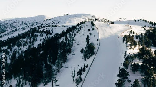 Aerial view of the ski slope and the snowy peaks of the mountains against the blue sky, Andorra