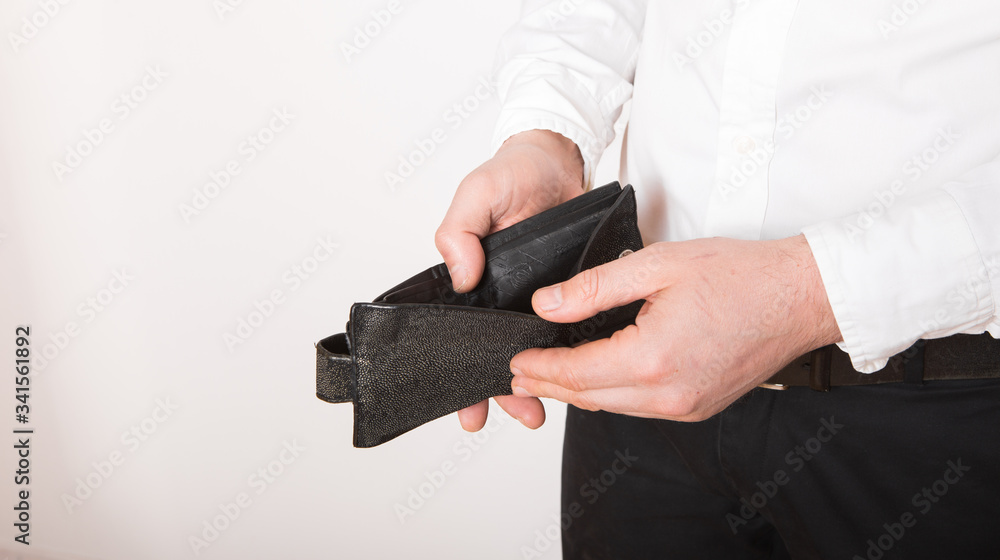 Fototapeta premium Bankruptcy - Business Person holding an empty wallet. Man showing the inconsistency and lack of money and not able to pay the loan and the mortgage.