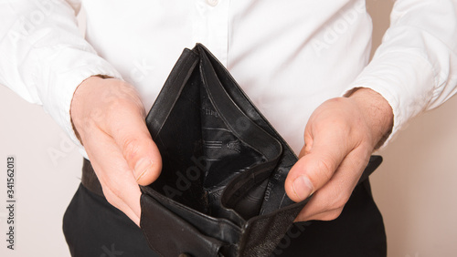 Bankruptcy - Business Person holding an empty wallet. Man showing the inconsistency and lack of money and not able to pay the loan and the mortgage.