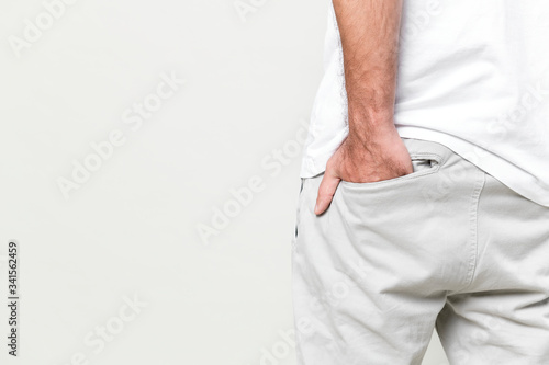 Man put his hand into back pocket of white plant