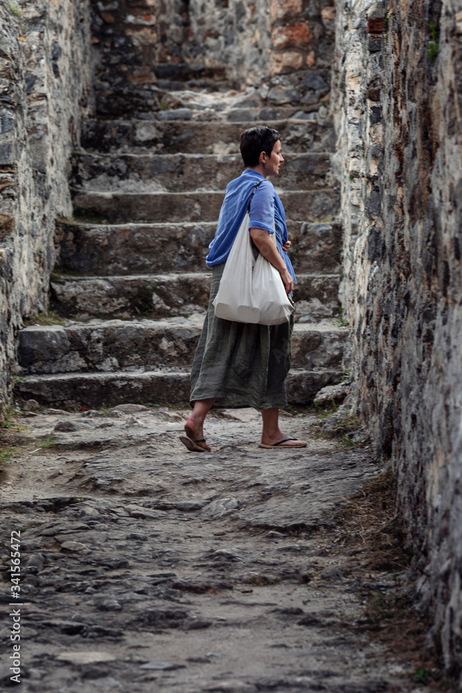 Woman tourist in the walls of the old fortress. Antiquity and the Middle Ages. Vertical. Woman tourist in the walls of the old fortress. Antiquity and the Middle Ages. Vertical.