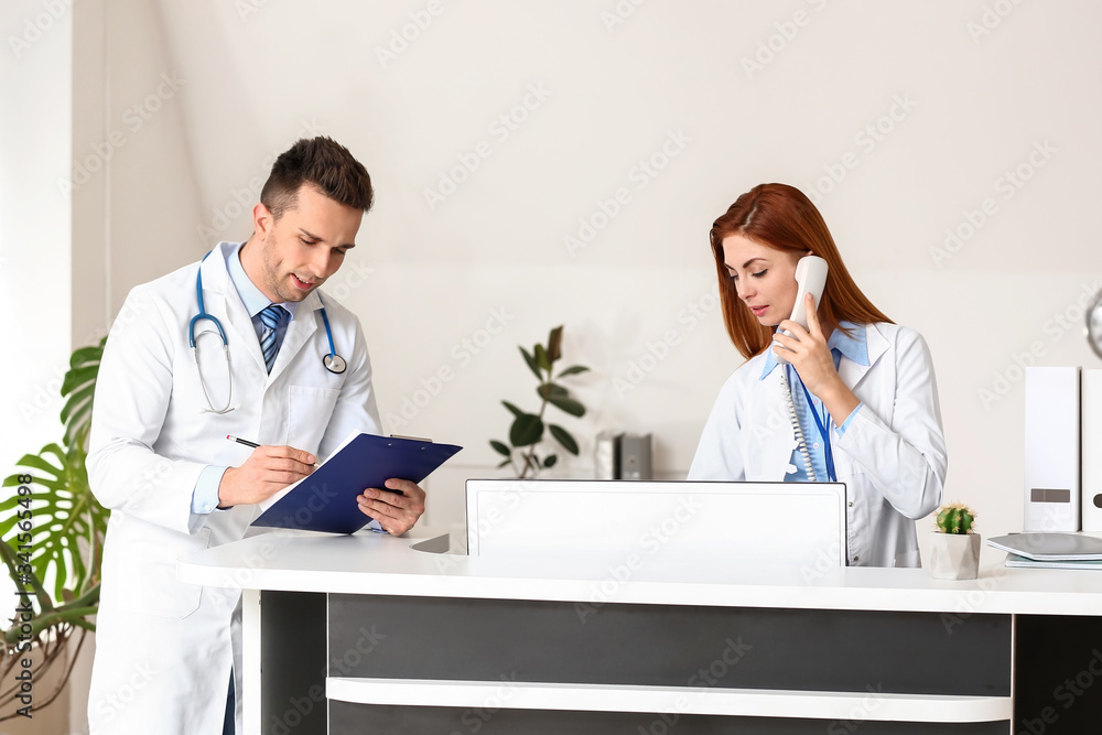 Fototapeta premium Female medical assistant with doctor in clinic