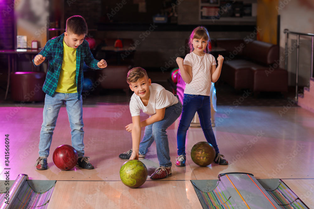 Fototapeta premium Little children playing bowling in club