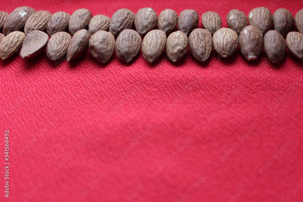 Almonds lined with a line on a red background. Almonds closeup with place for text. Nuts and dried fruits, healthy nutrition.