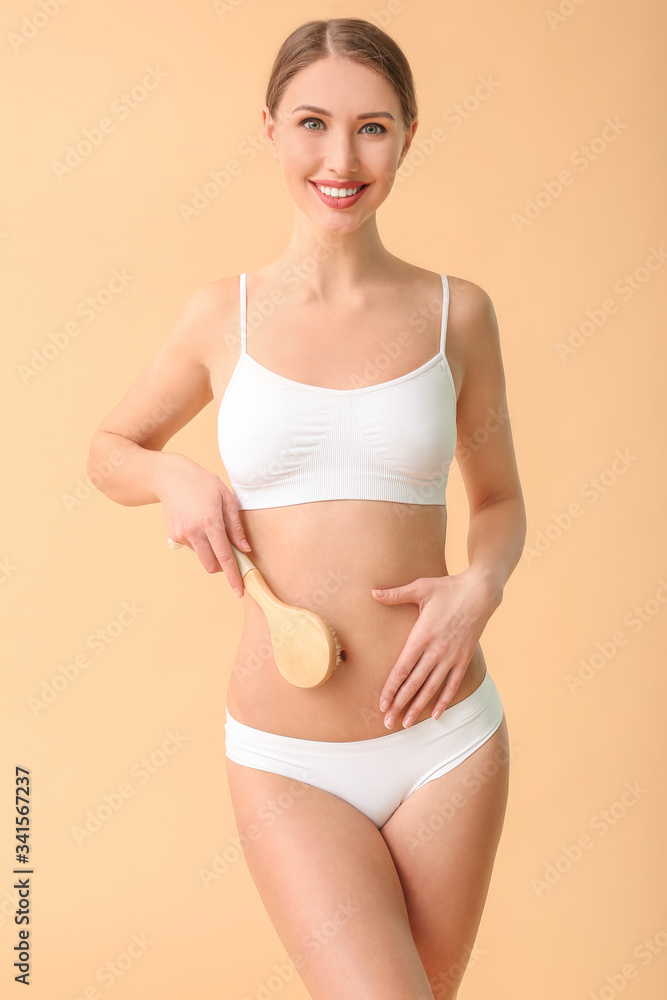 Obraz premium Woman with anti-cellulite massage brush on color background