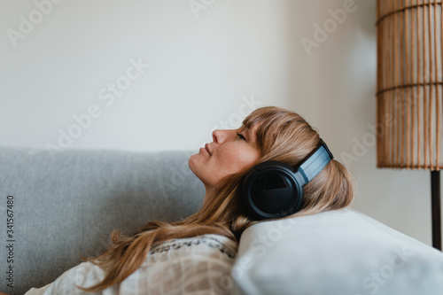 Woman listening to music at home during coronavirus pandemic photo