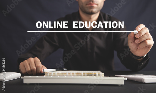 Man writing Online Education text in screen.