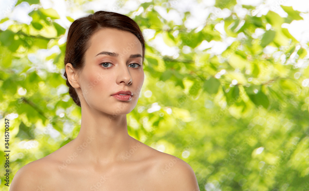 beauty, bodycare and people concept - beautiful young woman with bare shoulder over green natural background beauty, bodycare and people concept - beautiful young woman with bare shoulder over green natural background