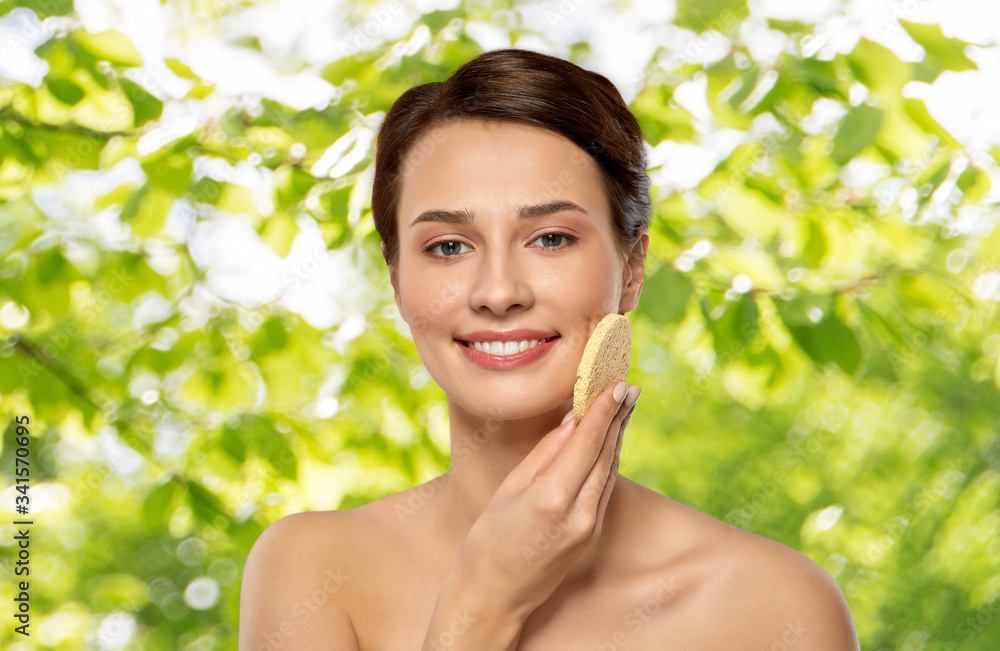 beauty, people and skincare concept - young woman cleaning face with exfoliating sponge over green natural background beauty, people and skincare concept - young woman cleaning face with exfoliating sponge over green natural background