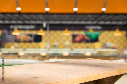 Supermarket background, Counter over blur grocery background, Wooden desk, table, shelf and blur woman shopping at supermarket, Wood counter for grocery store retail product display backdrop, template