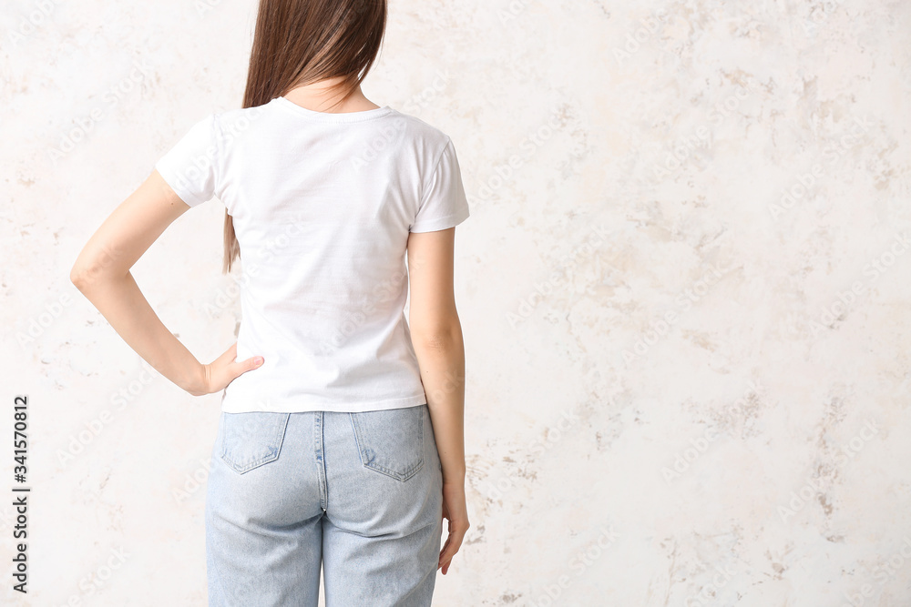 Young woman in stylish t-shirt on light background