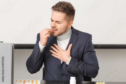 Ill young man taking medici...