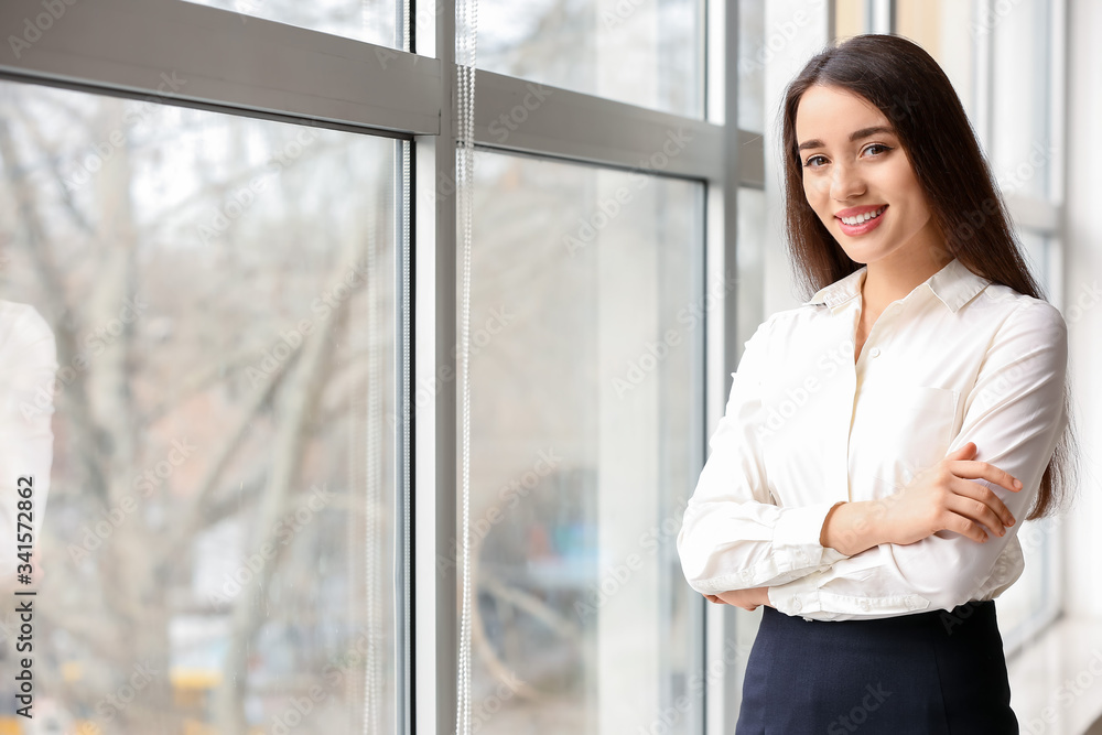 Portrait of beautiful young businesswoman near window in office Portrait of beautiful young businesswoman near window in office
