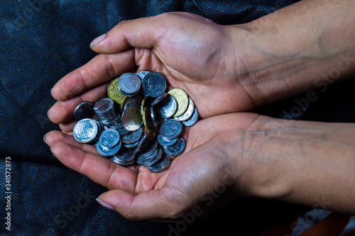 HANDS GIVING COINS IN A DARK BACKGROUND photo