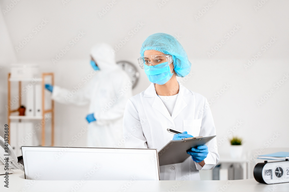 Female receptionist working at desk in clinic Female receptionist working at desk in clinic