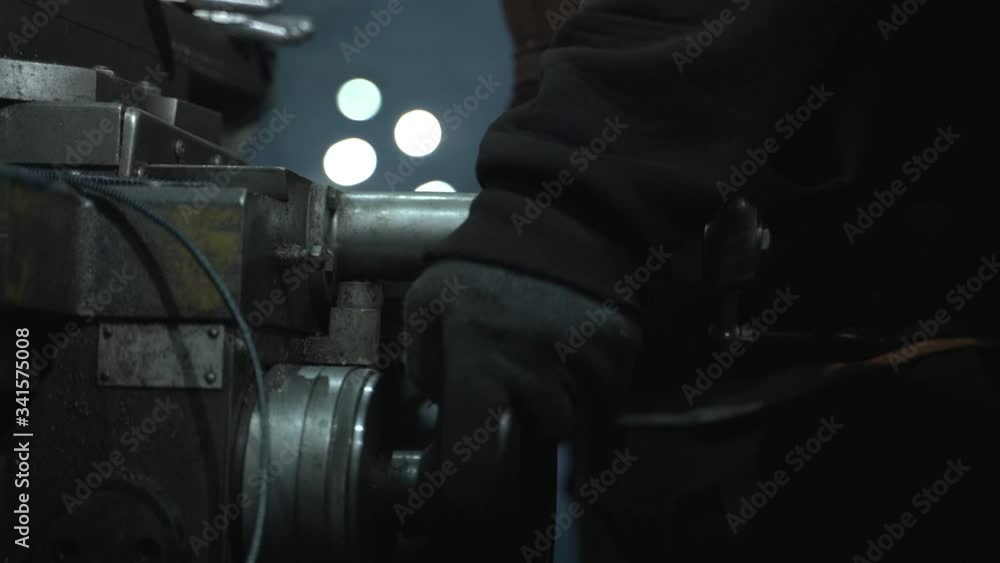 Worker rotate wheel on lathe machine. Metalworking. Turner working on the machine. Lathe work.