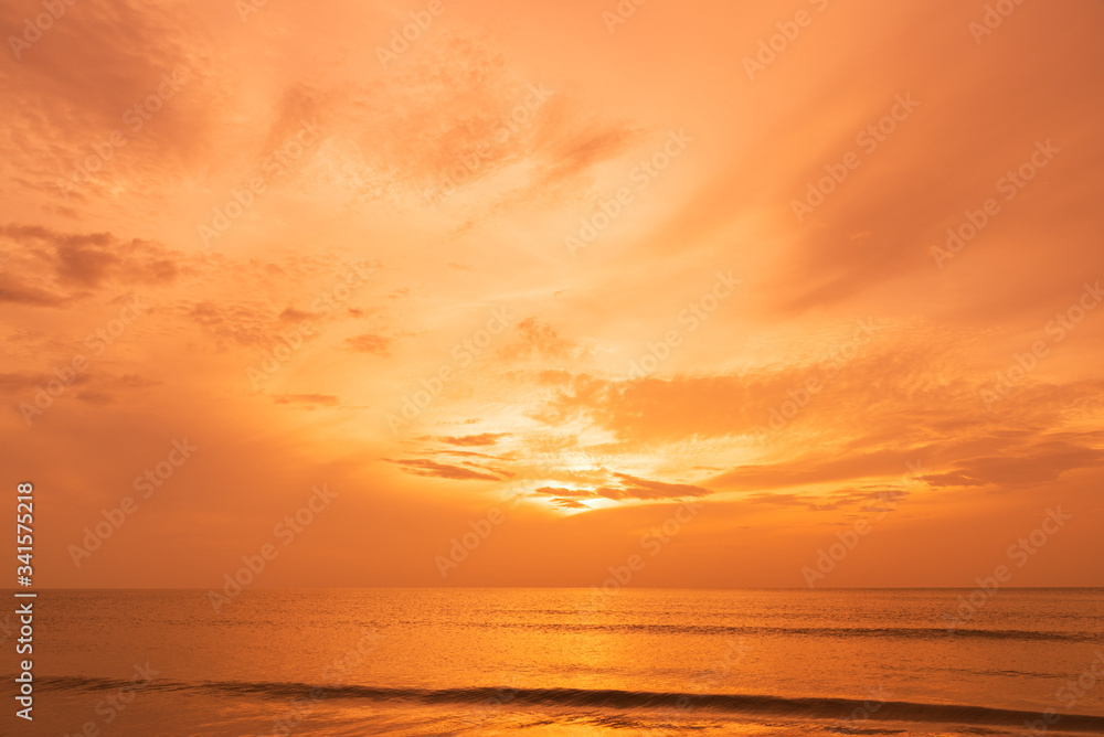 Fototapeta premium Beautiful orange sky reflection with smooth waves on the sea.