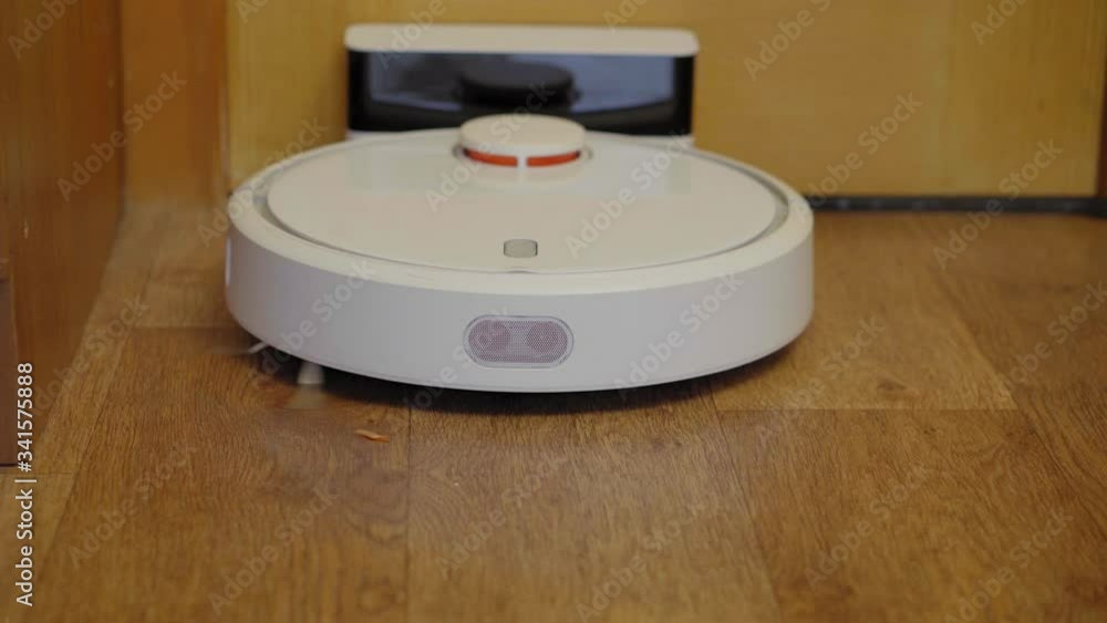 Robot vacuum cleaner on a wooden floor in a room Robot vacuum cleaner on a wooden floor in a room