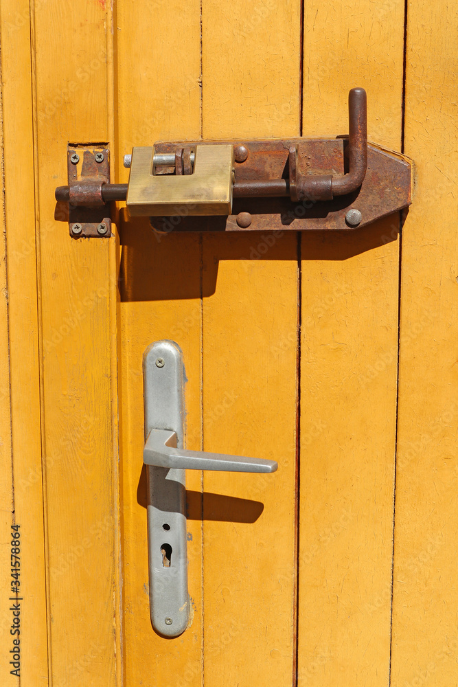 Rusty old latch and padlock on a door Rusty old latch and padlock on a door