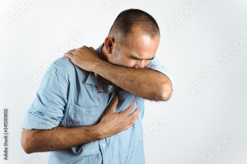 Canvas Print Man sneezing or coughing in his elbow to prevent spread the virus COVID-19 or Corona Virus on white background