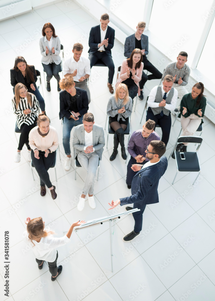 top view. listeners applauding the speaker at a business seminar.