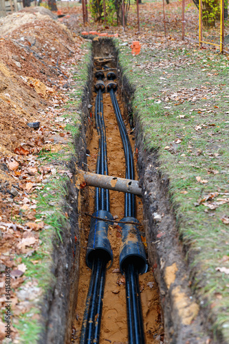 Laying an electrical cable in the ground. New electric line laying in a trench in the ground.