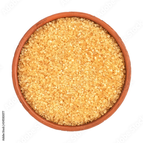 Brown cane sugar in a bowl isolated on white background, top view.