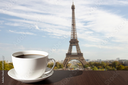 Cup of coffee on the table with view of Eiffel tower in Paris, France © Maria Vonotna
