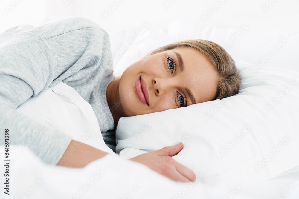 Image closeup of woman looking at camera while lying after sleep Image closeup of woman looking at camera while lying after sleep