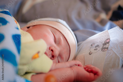 A newborn baby sleeps sweetly clasped hands fart by himself. Zodoroy dream, trust and parenthood. A red, swollen baby.