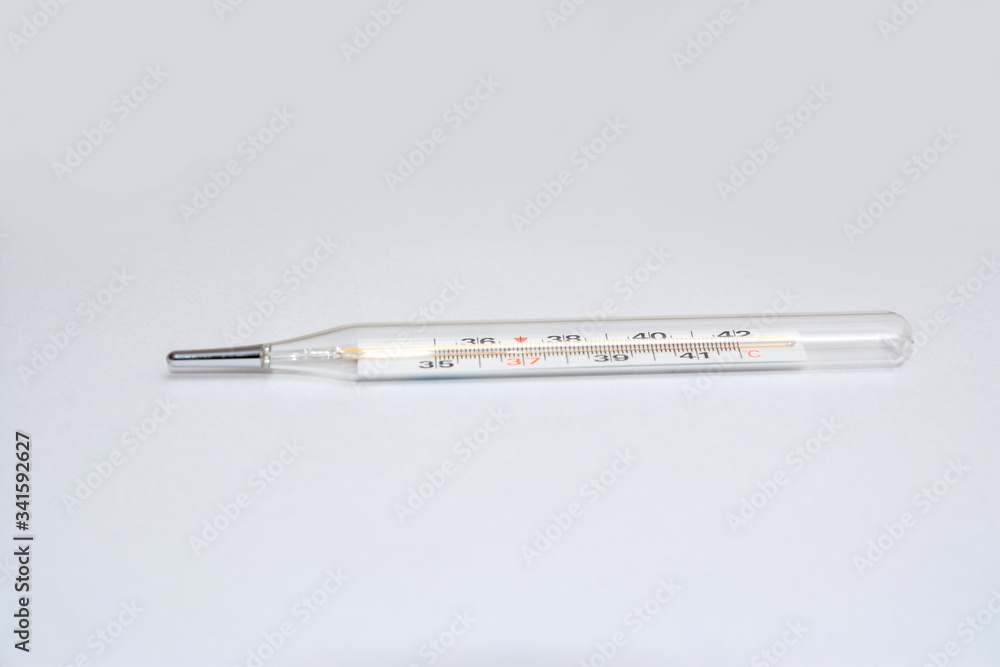 On white surface in center is placed a thermometer to measure the temperature. Glass mercury thermometer. On white surface in center is placed a thermometer to measure the temperature. Glass mercury thermometer.