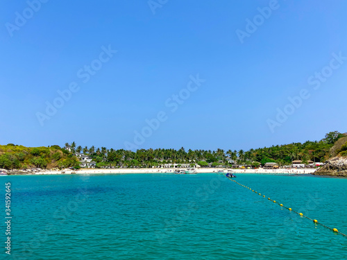 Fototapeta Naklejka Na Ścianę i Meble -  View from the boat to the beach on the island of Racha Yai in Thailand. Hotel among palm trees on a tropical island in the jungle, azure sea, landscape, concept of independent travel around the world