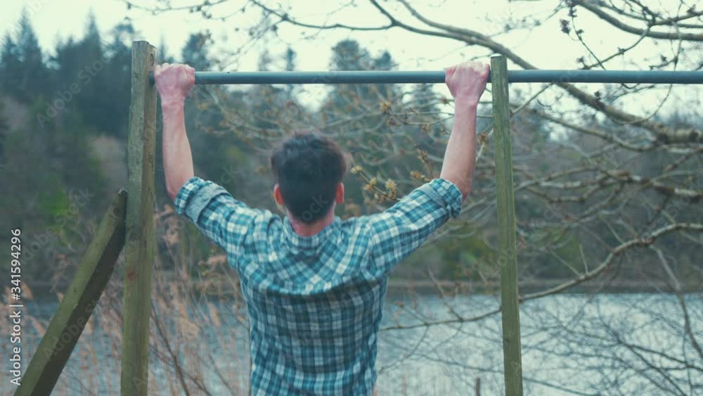 Young man doing wide grip pull ups with scapula retracted Young man doing wide grip pull ups with scapula retracted