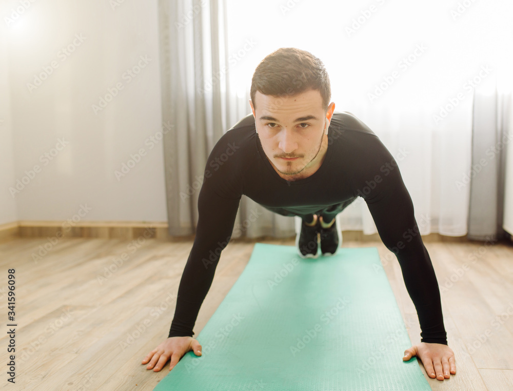 young man making sport exercises at home