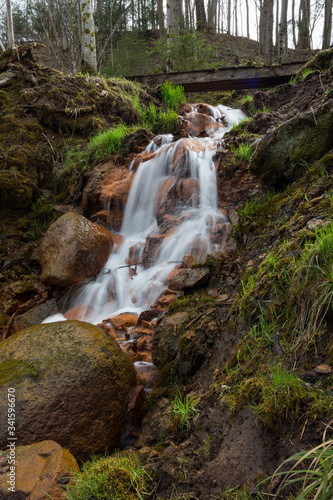 City Cesis  Latvia. Old waterfall with green moss and red rocks.