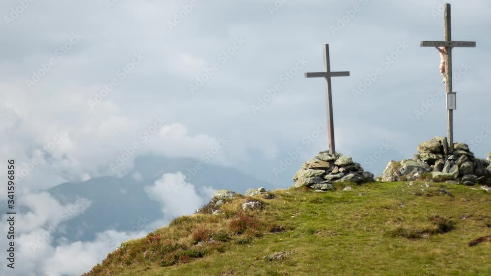 Timelapse zoom in of three large crucifixes on top of a mountain. Timelapse showing three large Christian crosses being held by large stone piles at the peak of a mountain during a cloudy day Timelapse zoom in of three large crucifixes on top of a mountain. Timelapse showing three large Christian crosses being held by large stone piles at the peak of a mountain during a cloudy day
