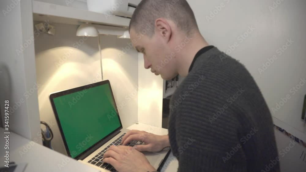 A Man Working On His Laptop With Blank Green Screen At The Office - Closeup Shot A Man Working On His Laptop With Blank Green Screen At The Office - Closeup Shot