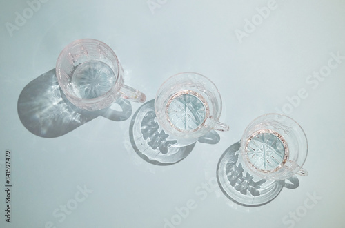 three clear crystal cups with handles stand in a row, the view from the top © Татьяна Громова