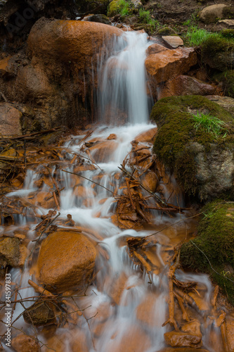 City Cesis  Latvia. Old waterfall with green moss and red rocks.