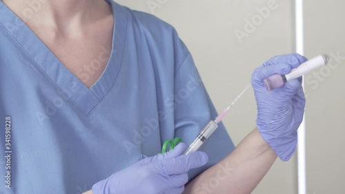 Nurse preparing Coronavirus Vaccine. Camera zoon in on transparent liquid vaccine photo
