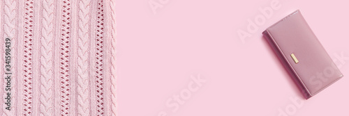 Beautiful taken  stylish fashionable cotton pink sweater and leather wallet on bright rose background.