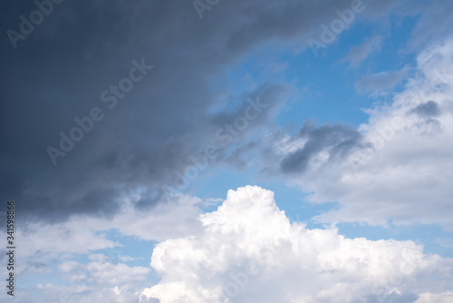 the bright blue sky in the summer midday with storm clouds