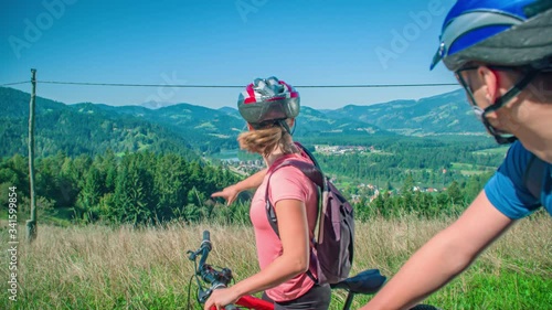 Cyclist couple stops to admire panorama in Vuzenica viewpoint. photo