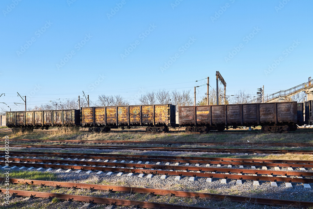 Old empty rusty train cars on rails in sunny day. Industrial crisis