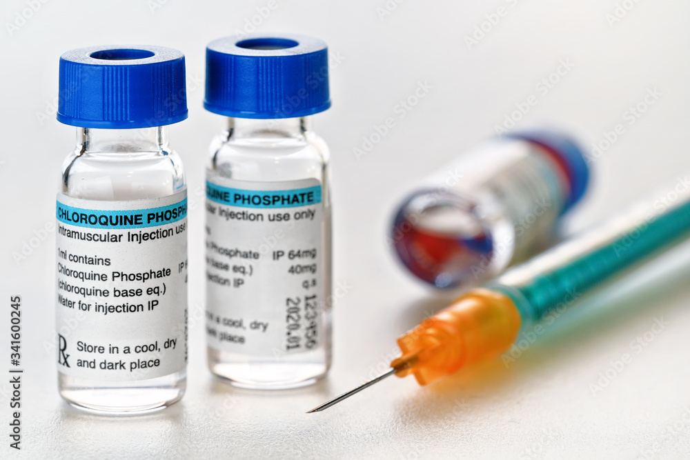 Chloroquine phosphate drug in small injection bottles with blue caps, orange green syringe near, closeup detail (own label design with dummy data - not real product) Potential coronavirus cure concept Chloroquine phosphate drug in small injection bottles with blue caps, orange green syringe near, closeup detail (own label design with dummy data - not real product) Potential coronavirus cure concept