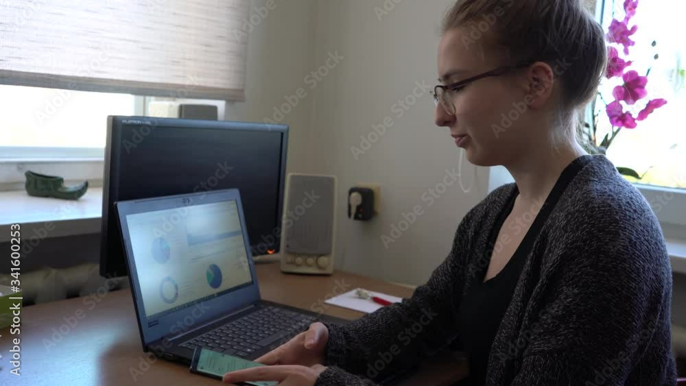 Woman is working from, checking smartphone Woman is working from, checking smartphone