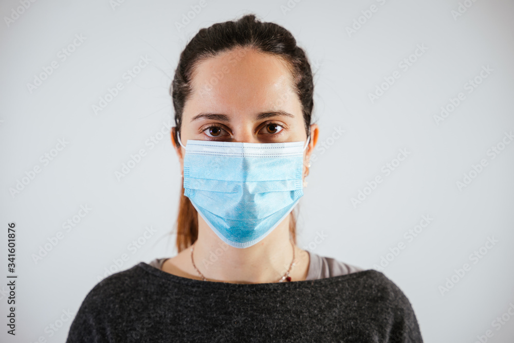 Portrait of a beautiful young woman with a medical mask of protection from the Coronavirus, Covid-19 - Millennial protects herself from the infection by wearing personal protection tools Portrait of a beautiful young woman with a medical mask of protection from the Coronavirus, Covid-19 - Millennial protects herself from the infection by wearing personal protection tools